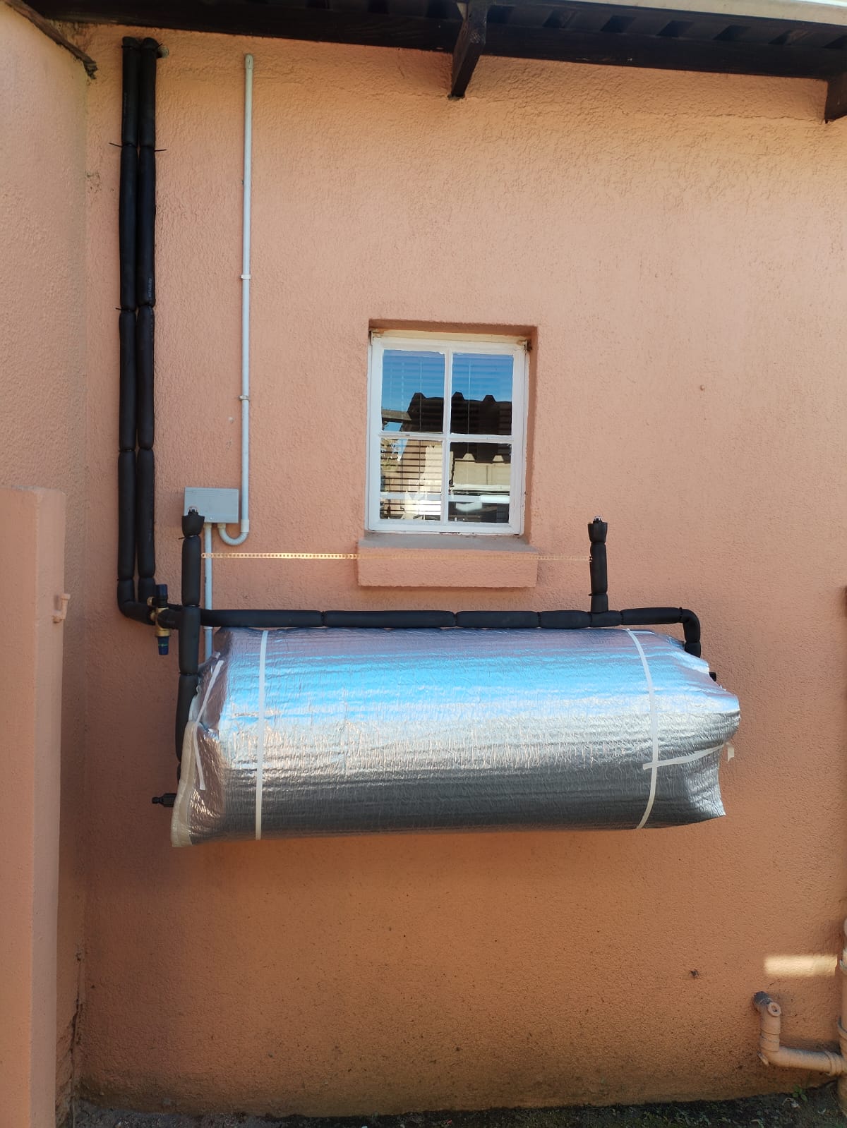 Wall-mounted geyser with insulated hot water pipework
