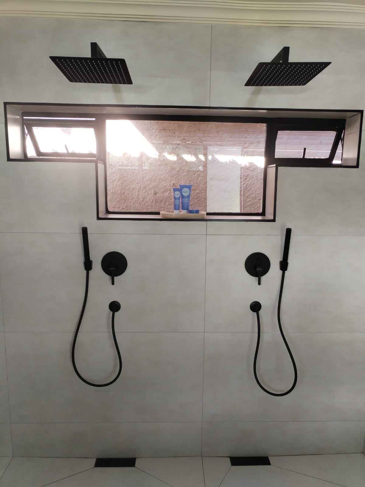 Double rainfall shower with matte black mixers and hand showers