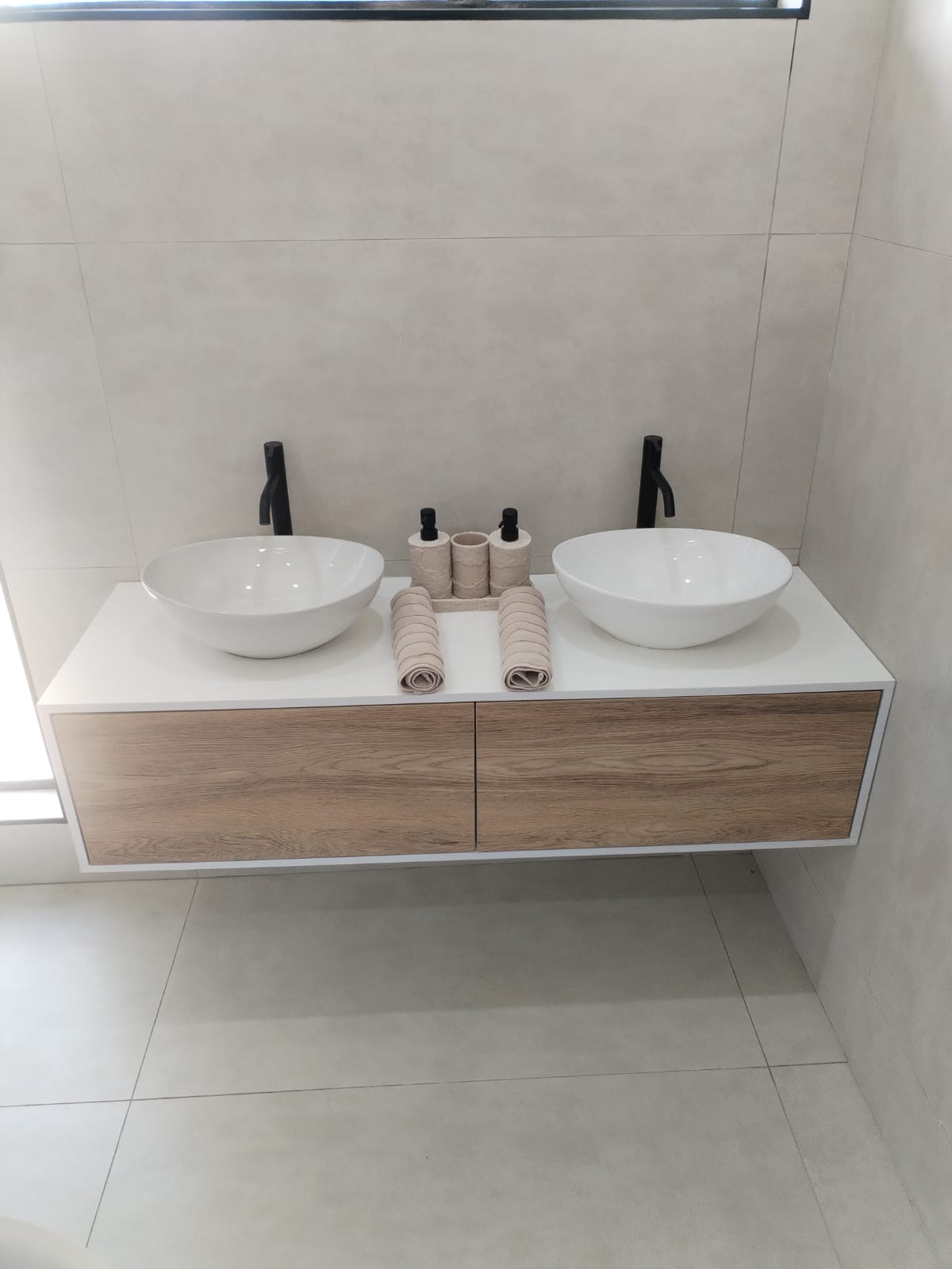 Floating vanity with twin counter basins and matte black taps
